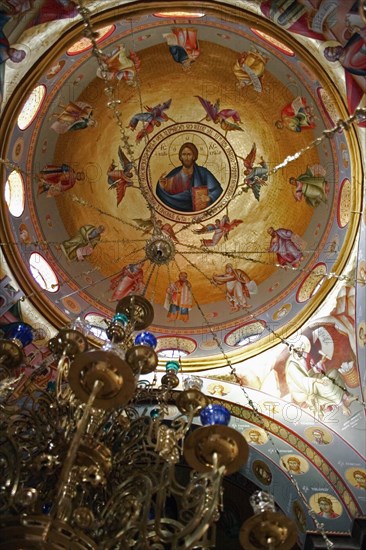 ISRAEL, Hazafon, Sea of Galilee, "Nazareth.  Interior of the Greek Orthodox Church of St. Gabriel also known as the Church of the Annunciation, located over the spring that fed Marys Well.  Interior of the   dome with painting of Jesus Christ encircled by the Saints with ornate candelabra hanging from centre. "