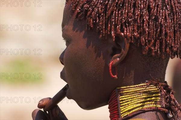 ETHIOPIA, Lower Omo Valley, Turmi, "Hamer Jumping of the Bulls initiation ceremony, Hamer girl, her hair greased with ocher colouring and animal fat into plaits known as Goscha"