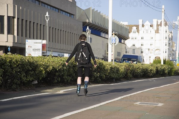 ENGLAND, East Sussex, Brighton, Rollerblading on the seafront promenade.