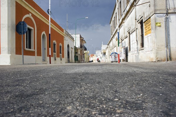 ITALY, South, Characteristic empty street lined with old coloured buildings.  Low angle shot from tarmac level.