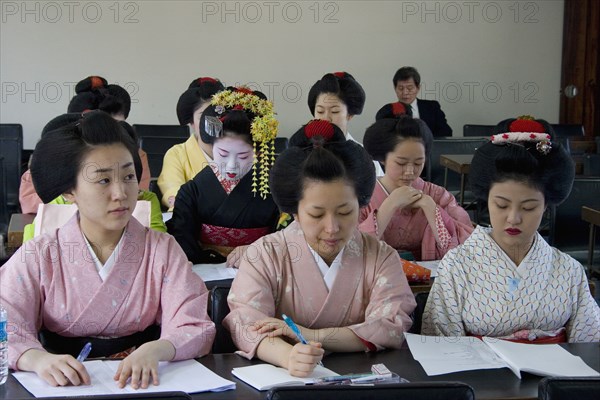 JAPAN, Honshu, Kyoto, "Gion District, the neighbourhood where Geisha live, study and perform.  Geisha and Maiko apprentice Geisha dressed in kimonos attending a class at Mia Garatso school of Geisha."