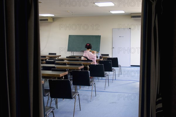 JAPAN, Honshu, Kyoto, "Gion District, the neighbourhood where Geisha live, study and perform.  Geisha practicing her Japanese flute skills in an empty classroom at the Mia Garatso school for Geisha."