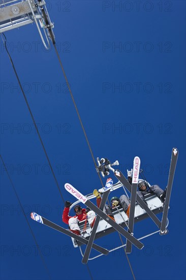 20091059 View cable ski lift chair against blue sky with clouds. American North America United States America White  WeatherTravelTransportDominant RedDominant WhiteDominant BlueRegion - North AmericaPeople - GroupSport Jon Hicks 20091059 USA Colo