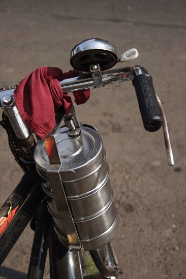 INDIA, Maharashtra, Mumbai, Cropped shot of bicycle with tiffin box tied to handlebars.