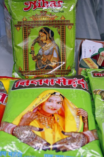 INDIA, Rajasthan, Jodhpur, Plastic packets of henna for sale illustrated with pictures of attractive women with henna patterns on hands and wrists.