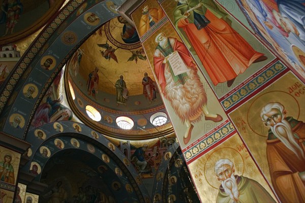 ISRAEL, Hazafon, Sea of Galilee, "Nazareth.  Interior of the Greek Orthodox Church of St. Gabriel also known as the Church of the Annunciation, part view of domed roof and archways decorated with paintings of biblical scenes and the saints, wall hangings and tiled mosaics.  Church is located over the spring that fed Marys Well. "