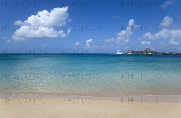 WEST INDIES, St Lucia, Gros Islet, View out to sea from Reduit Beach in Rodney Bay towards Pigeon Island with yachts at anchor in the bay