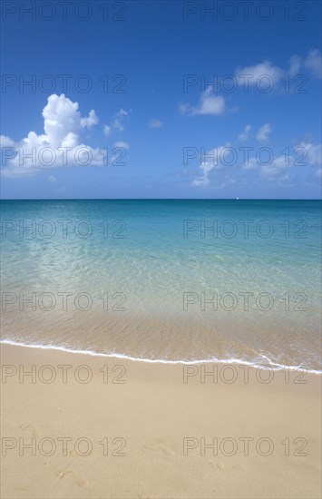 WEST INDIES, St Lucia, Gros Islet, View out to sea from Reduit Beach in Rodney Bay with a yacht sailing on the horizon