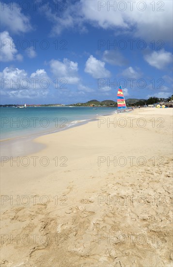 WEST INDIES, St Lucia, Gros Islet, Reduit Beach in Rodney Bay with tourists in the water and on the beach with yachts at anchor in the bay