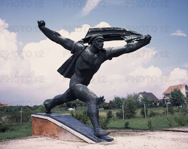 HUNGARY, Near Budapest, Statue Park. Communist statue of The striding soldier. Republic of Councils Monument