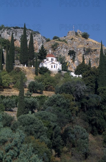 GREECE, Peloponnese, Molai , White church with red tilled dome on tree covered hillside
