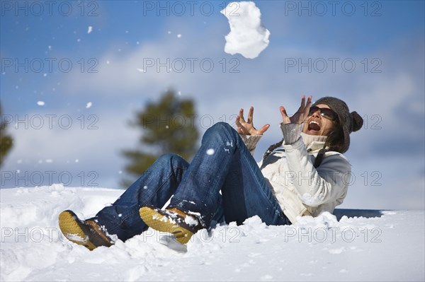 20091042 Girls trying catch snowball. American North America One individual Solo Lone Solitary United States America  Dominant WhiteDominant BluePeople - Single PersonPeople - Age = Middle AgedRegion - North AmericaLeisure ActivitiesWeather Jon Hick