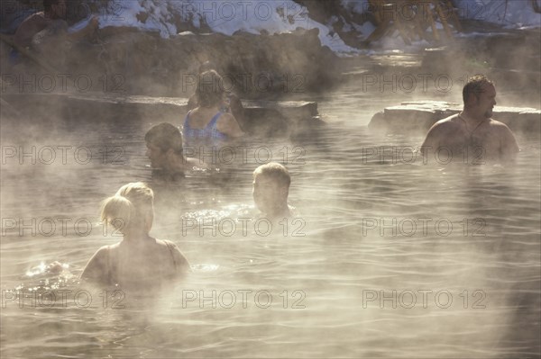 20091048 People outdoor hot pool spa resort  with steam rising cold air. Property Released American Holidaymakers North America Tourism Tourist United States America  WeatherWaterDominant BrownPeople - Age = Middle AgedTRAVEL BrochureTravelTourists