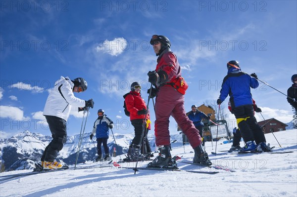 20091052 Group skiers about descend mountain. American Holidaymakers North America Tourism Tourist United States America  Dominant YellowDominant RedDominant BluePeople - GroupLeisure ActivitiesSportWeatherTouristsRegion - North America Jon Hicks