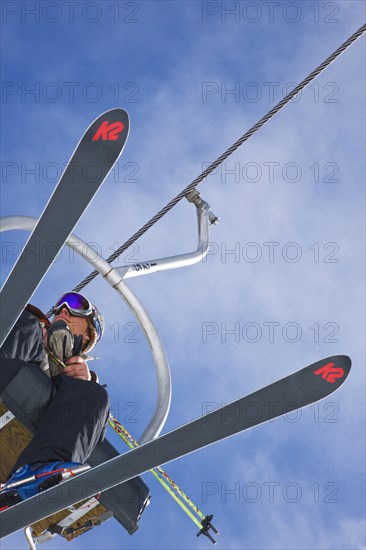 20091054 Skier ski lift chair. American Holidaymakers North America One individual Solo Lone Solitary Skiing Skis Tourism Tourist United States America  Dominant BluePeople - Single PersonLeisure ActivitiesSportTouristsWeatherRegion - North America