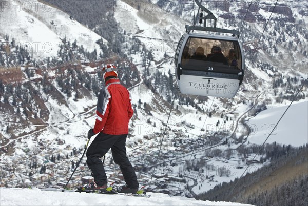 20091055 Skier slopes with cable car ski lift overhead passing by. Property Released American Automobile Automotive Cars Holidaymakers Motorcar North America Skiing Skis Tourism Tourist United States America  Dominant RedDominant WhitePeople - Portraits