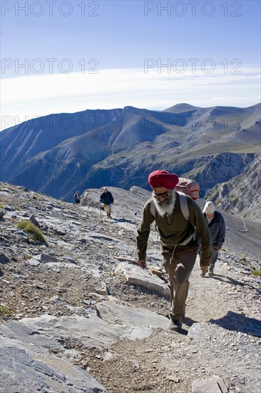 GREECE, Macedonia, Pieria, Olympus.  Group of four climbing steep slope of Mount  Olympus towards the highest peak called Mytikas.