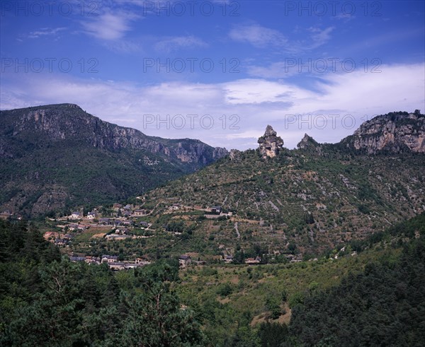 FRANCE, Midi-Pyrenees, Aveyron, View across Gorge de la Jonte junction with the Tarn Gorge at Le Rozier village set on terraced hillside topped with pinnacles of eroded rock.