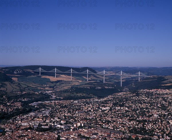 FRANCE, Midi-Pyrenees, Aveyron, Millau.  Cityscape with Millau bridge beyond which carries the A75 motorway from Beziers to Clermont Ferrand.