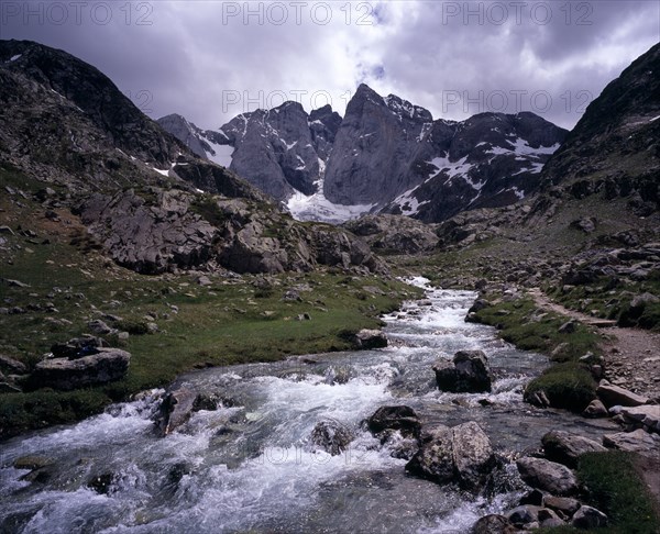 FRANCE, Midi-Pyrenees, Hautes-Pyrenees, "Upper Vallee de Gaube.  Fast flowing river tumbling over rocks in mountain landscape with central peak and north face of Vignemale 3298 m high, south of Pont d’Espagne."