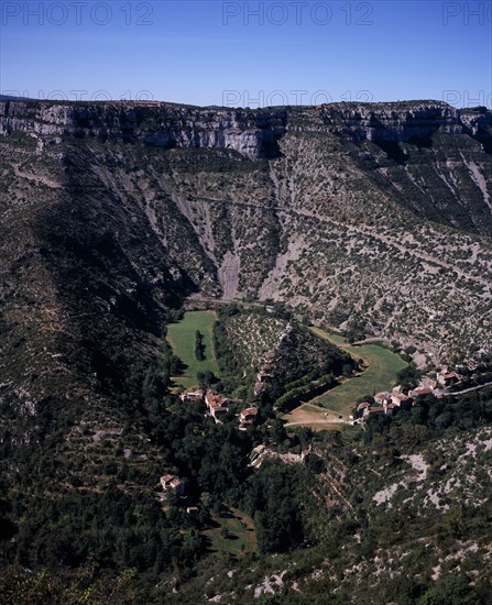 FRANCE, Midi-Pyrenees, Tarn, "Elevated view over Cirqe de Navacelles a landform created by glacial erosion, with former oxbow lake now dried up, beside small settlement."