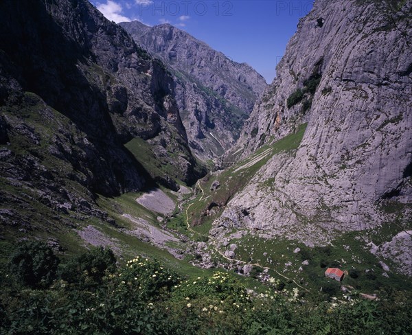 SPAIN, Asturias, Picos de Europa, "View north down Arroyo del Tejo Valley from Bulnes El Castillo with steep sided, eroded limestone cliffs and narrow, winding mountain path."