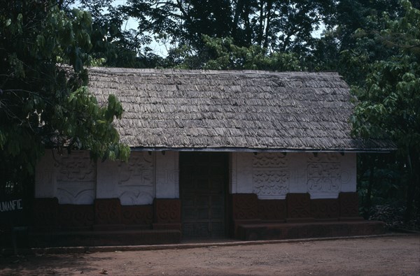 GHANA, Ashanti, Traditional thatched house with intricate patterns on walls.