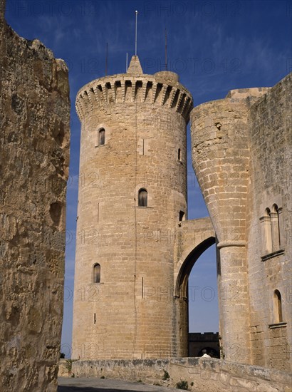 SPAIN, Balearic Islands, Mallorca, Palma.  Circular defence tower and bridge of fourteenth century Belver Castle with tourist visitor just seen above wall.
