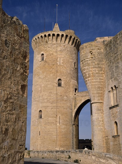 SPAIN, Balearic Islands, Mallorca, Palma. Circular defence tower and bridge of fourteenth century Belver Castle with tourist visitor just seen above wall.