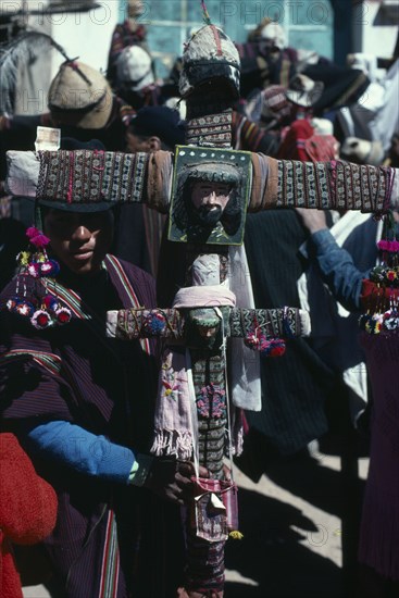 BOLIVIA, Macha , Tingku Festival Day. Man holding a large decorated cross with the face of Jesus Christ. North of Potosi