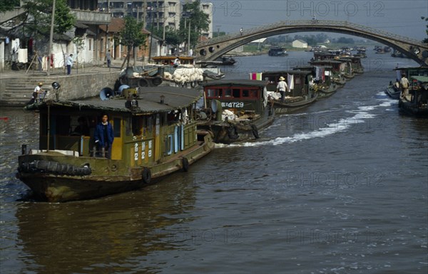 CHINA, Jiangsu Province, Transport, Barge train travelling down the Grand Canal under bridge between Suzhou and Wuxi.