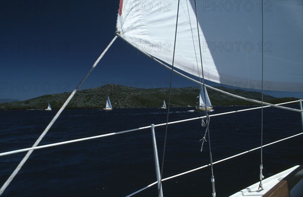 SPORT, Water Sport, Sailing, Flotilla sailing Cobra 850’s. View from deck of yacht with section of white sail on the South Ionian Sea