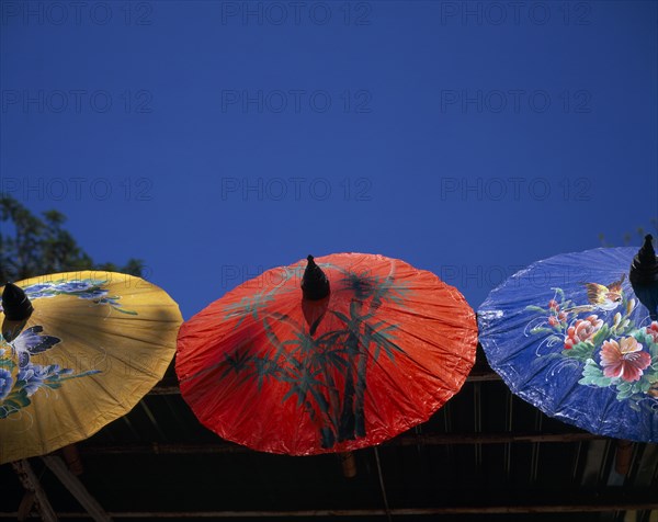 THAILAND, Chiang Mai Province, Bor Sang, "Bor Sang Umbrella and Sankampaeng Handicraft Festival.  Yellow, red and blue umbrellas painted with flowers, birds and bamboo.  For more than 100 years Bor Sang village has been associated with the production of umbrellas made from Sa paper derived from mulberry tree bark.  "