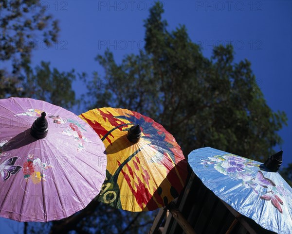 THAILAND, Chiang Mai Province, Bor Sang, "Bor Sang Umbrella and Sankampaeng Handicraft Festival.  Blue, yellow and purple umbrellas painted with flowers, butterflies and sunset.   For more than 100 years Bor Sang village has been associated with the production of umbrellas made from Sa paper derived from mulberry tree bark.  "
