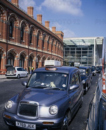 ENGLAND, London, St Pancras , St Pancras International exterior showing both new  terminal for Eurostar trains to continental Europe and original buildings with line of waiting taxis outside.