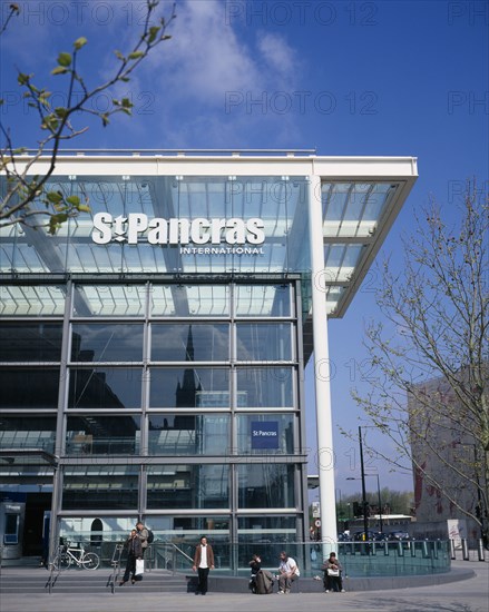 ENGLAND, London, St Pancras , St Pancras International exterior.  New security sealed terminal for Eurostar trains to continental Europe with passengers waiting on steps in the sunshine outside.