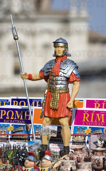 ITALY, Lazio, Rome, Souvenir stall in the Forum with statue of a uniformed Roman soldier among map guides in different languages