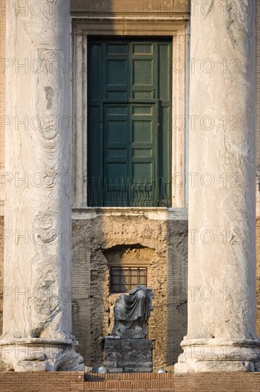 ITALY, Lazio, Rome, Broken seated statue between two columns at the entrance of the Temple of Antoninus and Faustina in the Forum