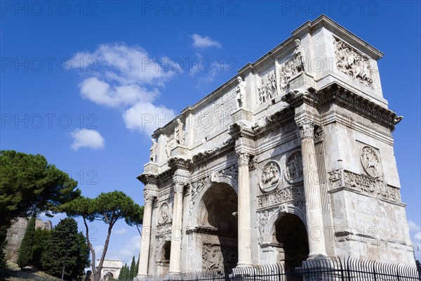 ITALY, Lazio, Rome, The south face of the triumphal Arch of Constantine with the Arch of Titus in the background