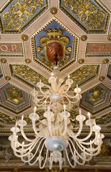 ITALY, Lazio, Rome, Capitoline Museum Palazzo Dei Conservatore chandelier hanging from the ceiling in the Palace with SPQR visible on the ornately decorated ceiling