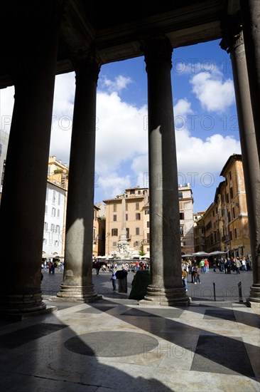 ITALY, Lazio, Rome, Piazza della Rotonda seen through the granite columns of the Pantheon with tourists walking in the square