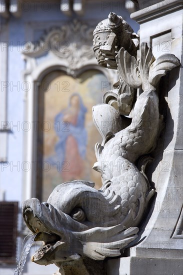 ITALY, Lazio, Rome, Detail of a dolphin on the Fountain of Piazza Della Rotonda by Giacomo Della Porta in 1575 with a religious fresco on the wall of a building beyond