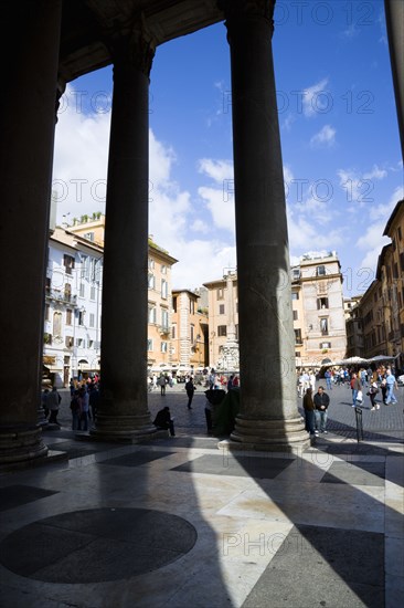 ITALY, Lazio, Rome, Piazza della Rotonda seen through the granite columns of the Pantheon with tourists walking in the square