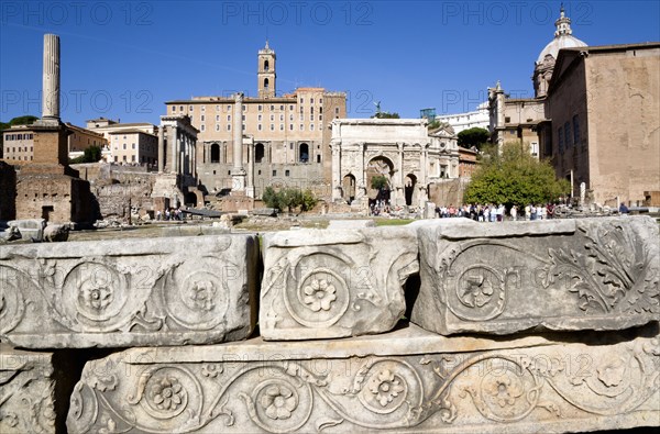 ITALY, Lazio, Rome, The Forum with tourists. Details of ruin fragments with the Arch of Septimius Severus in the centre