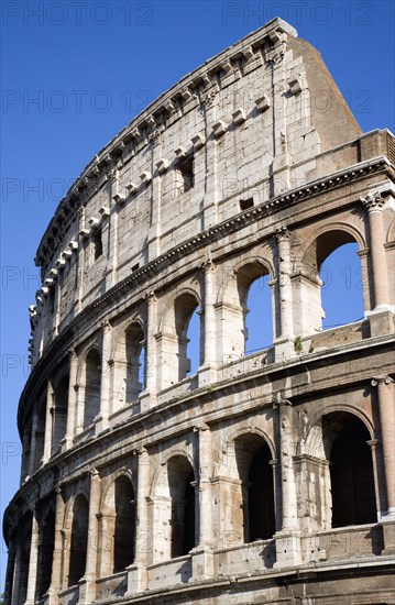 ITALY, Lazio, Rome, Detail of The Colosseum amphitheatre exterior with tourists walking past built by Emperor Vespasian in AD 80 in the grounds of Domus Aurea the home of Emperor Nero