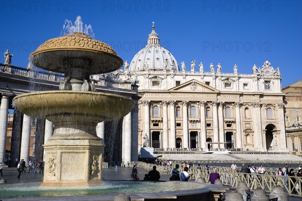 ITALY, Lazio, Rome, Vatican City The Basilica of St Peter and the square or Piazza San Pietro with tourists around a water fountain in the foreground