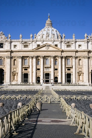 ITALY, Lazio, Rome, Vatican City The Basilica of St Peter with tourists at the entrance and empty seating for the Papal audience in the Piazza San Pietro