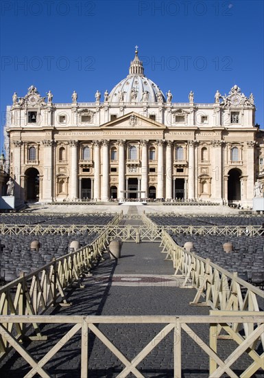 ITALY, Lazio, Rome, Vatican City The Basilica of St Peter with tourists at the entrance and empty seating for the Papal audience in the Piazza San Pietro