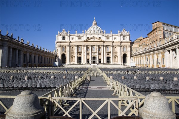 ITALY, Lazio, Rome, Vatican City The Basilica of St Peter with tourists at the entrance and empty seating for the Papal audience in the Piazza San Pietro