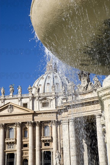 ITALY, Lazio, Rome, Vatican City The Basilica of St Peter and the square or Piazza San Pietro with tourists and a water fountain in the foreground